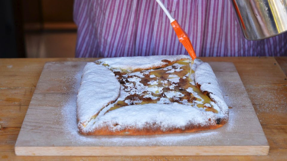 Tvaroh pokapeme bohatě rozpuštěným máslem. Zbytkem másla potřeme okraje koláče