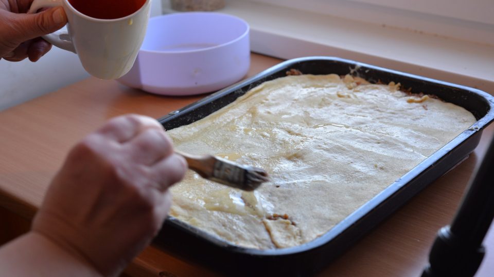 Poslední plát těsta potřeme vajíčkem a posypeme sekanými ořechy