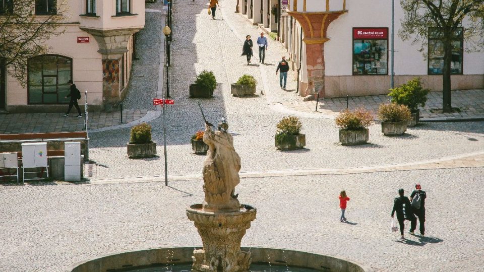 Barokní Neptunova kašna na Masarykově náměstí a pohled do ulice Matky Boží. V pozadí Brána Matky Boží, která je jedinou dochovanou historickou bránou do města