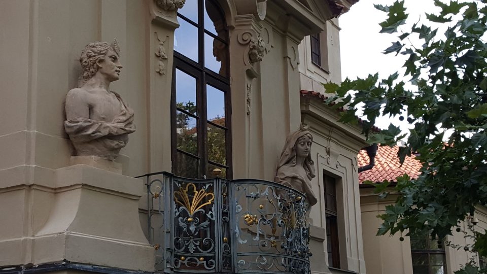 Dvojice bust symbolizujících Den a Noc nad současnou kavárnou