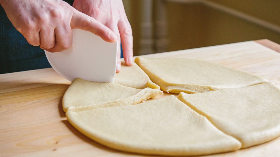 Nakynuté těsto na loupáky vyválíme do kruhu a nařežeme na osminky