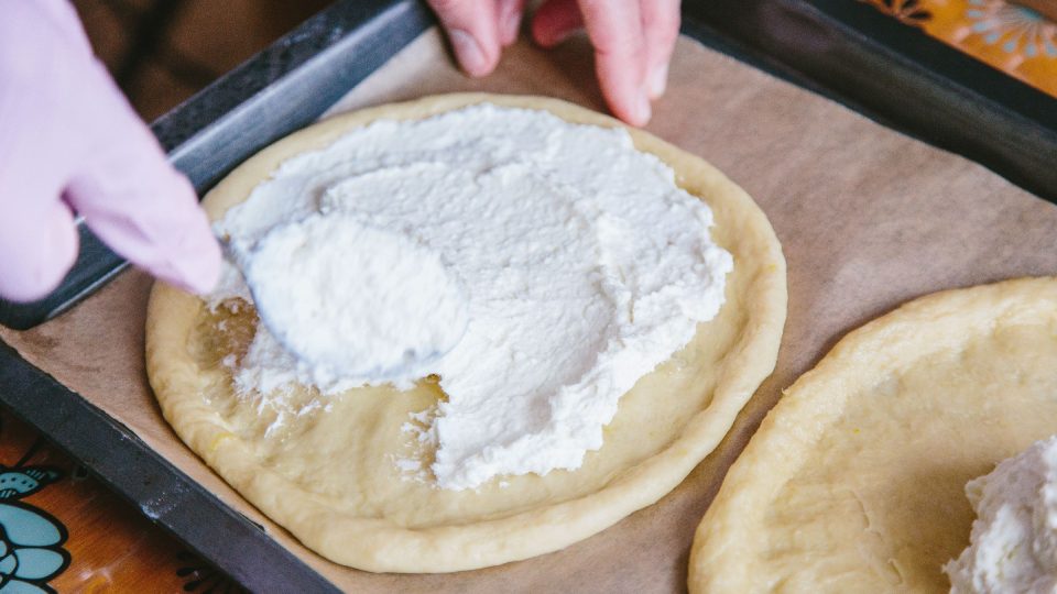 Náplň na koláč naneseme od prostředka a roztíráme lžící ke krajům