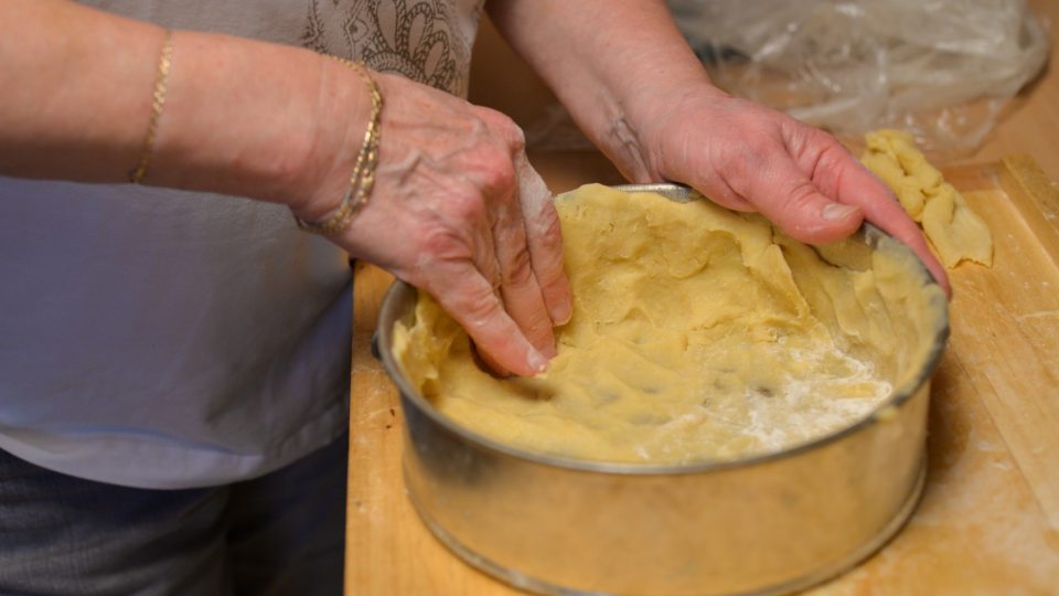 Těsto překlopíme dovnitř dortové formy, sejmeme fólii a vytlačíme těsto do krajů